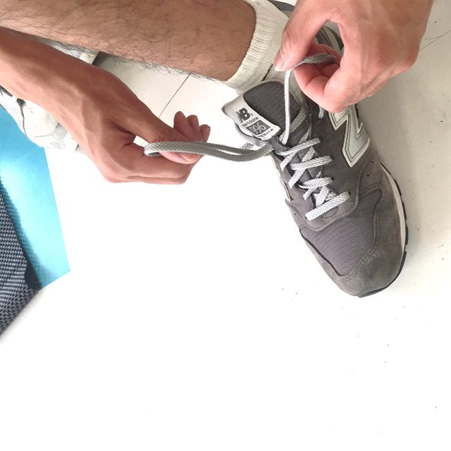 靴を履いて、靴ひもを結び直しているところ